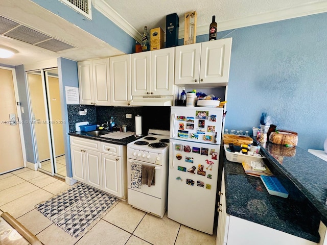 kitchen with light tile patterned floors, white cabinets, and white appliances