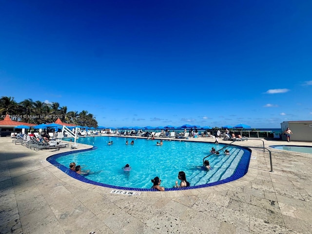 view of pool featuring a patio and a water view