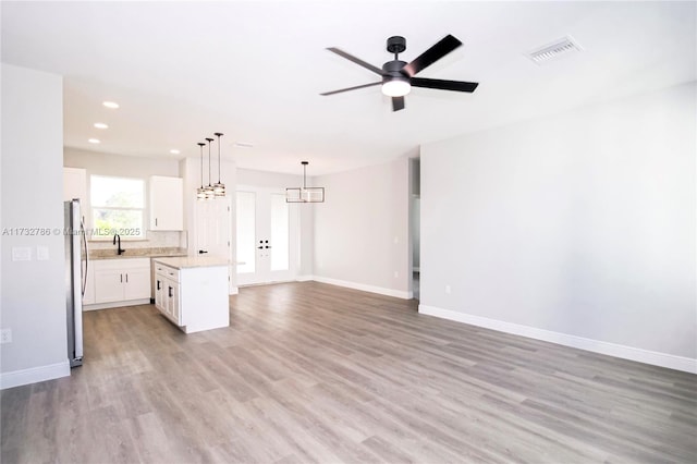 interior space featuring ceiling fan, sink, and light wood-type flooring