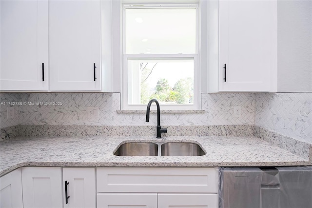 kitchen with sink, white cabinets, and light stone counters