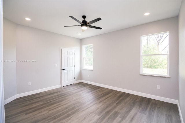 spare room with ceiling fan, dark hardwood / wood-style floors, and a wealth of natural light