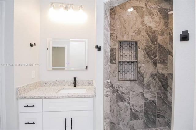 bathroom with vanity and tiled shower