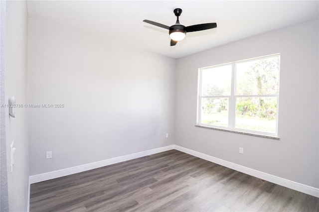 spare room featuring dark wood-type flooring and ceiling fan