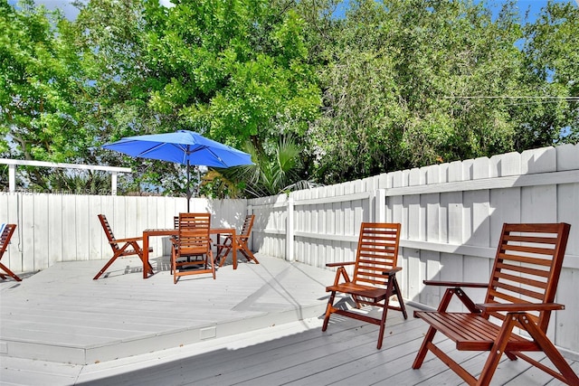 wooden terrace featuring outdoor dining space and fence