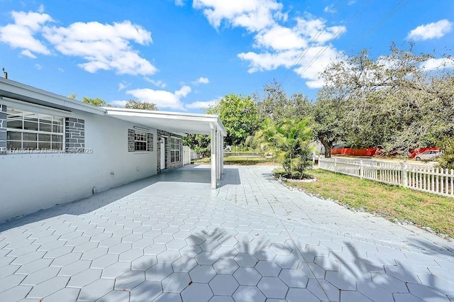 view of patio featuring a carport and fence