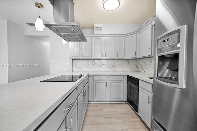 kitchen featuring black appliances, tasteful backsplash, light countertops, and island range hood