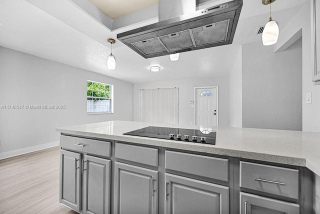 kitchen with black electric cooktop, exhaust hood, light wood-style floors, hanging light fixtures, and gray cabinets