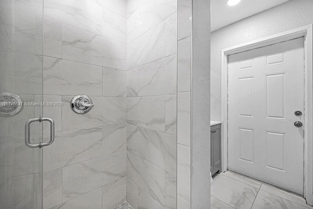 bathroom with a textured wall, marble finish floor, and a shower stall