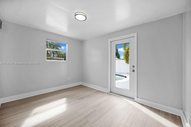 spare room featuring wood finished floors and baseboards