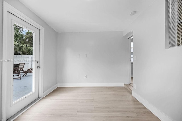 unfurnished room featuring baseboards and light wood finished floors