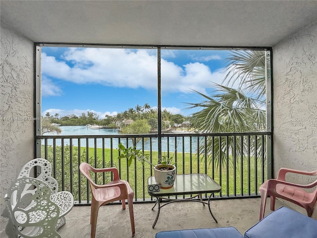 sunroom / solarium with a water view and a healthy amount of sunlight