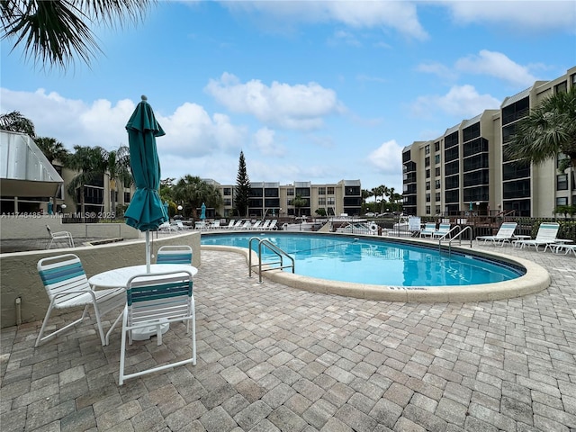 pool with a patio area and fence