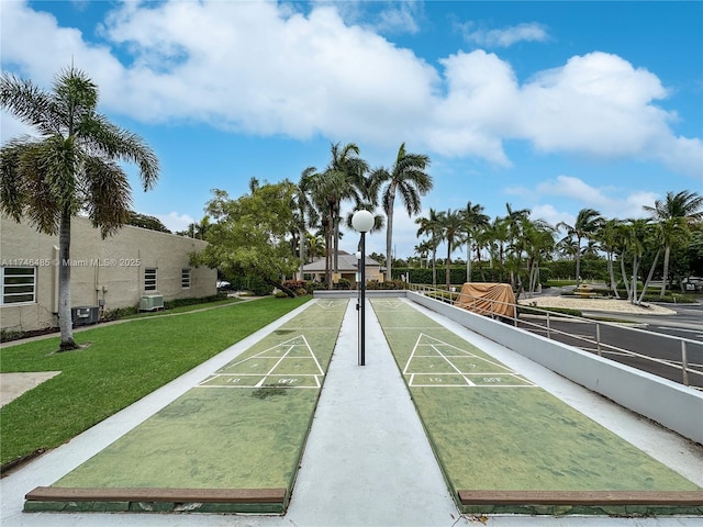 view of community with shuffleboard and a lawn