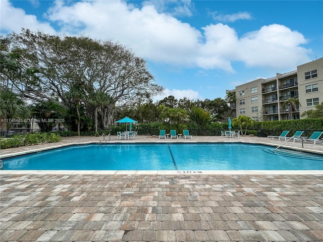 pool with fence and a patio