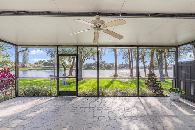 unfurnished sunroom with a water view and ceiling fan