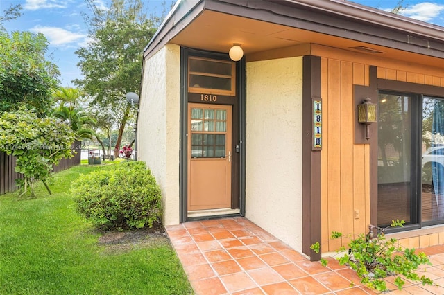 entrance to property with a lawn