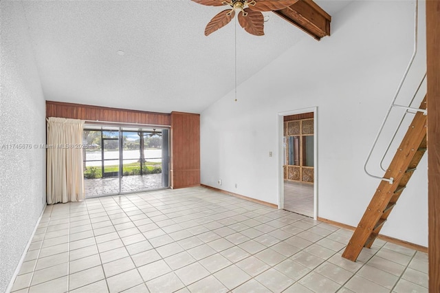 tiled spare room featuring ceiling fan, beam ceiling, high vaulted ceiling, a textured ceiling, and wood walls