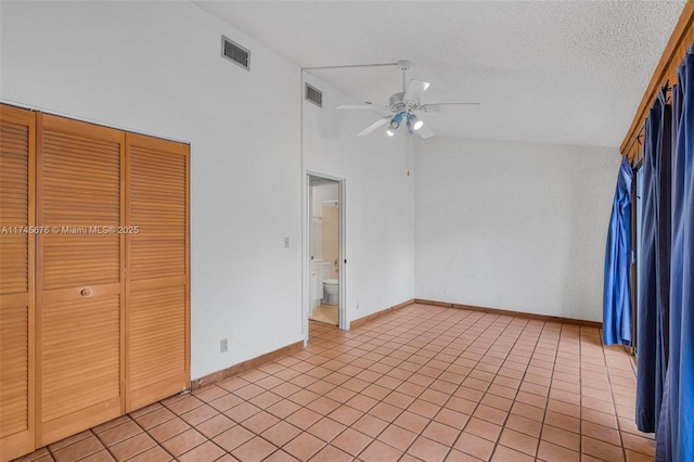 unfurnished bedroom featuring high vaulted ceiling, light tile patterned floors, ceiling fan, a textured ceiling, and a closet