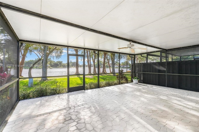 unfurnished sunroom featuring a water view and ceiling fan