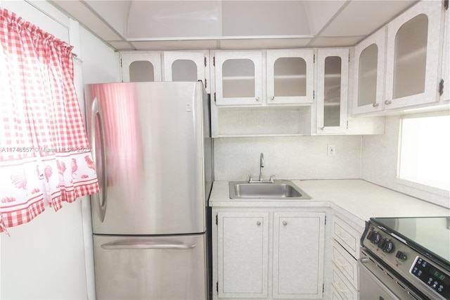 kitchen with backsplash, appliances with stainless steel finishes, sink, and white cabinets