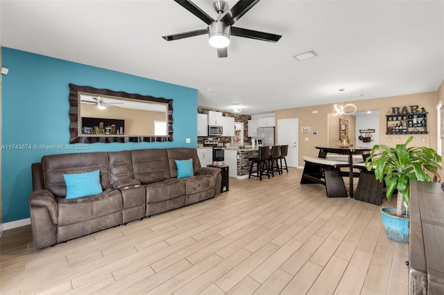 living room with light hardwood / wood-style flooring and ceiling fan