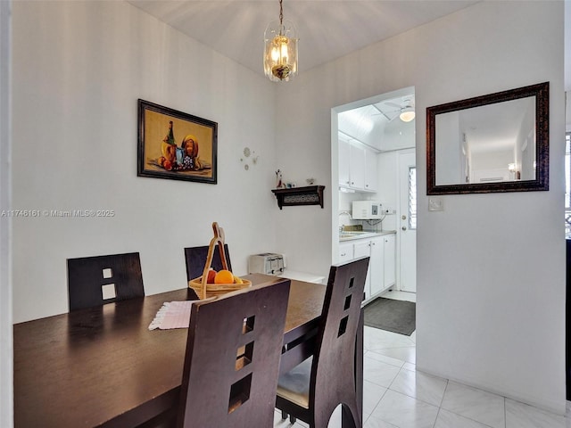 dining space with an inviting chandelier, sink, and light tile patterned floors