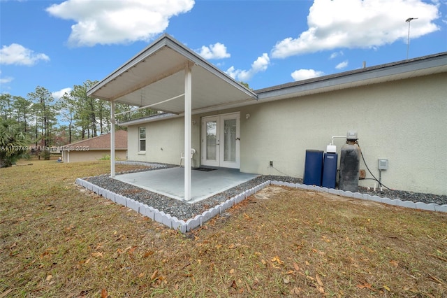 back of house with a patio, french doors, a lawn, and stucco siding