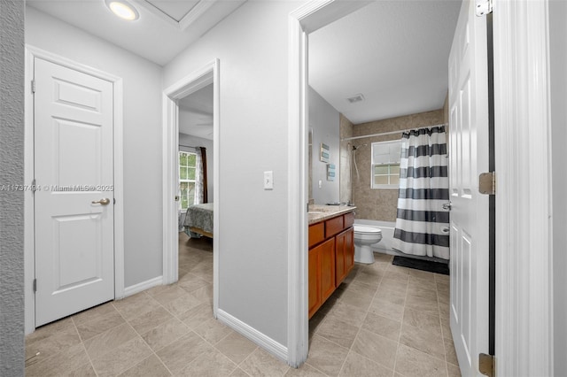 ensuite bathroom with visible vents, baseboards, toilet, shower / bath combo with shower curtain, and vanity