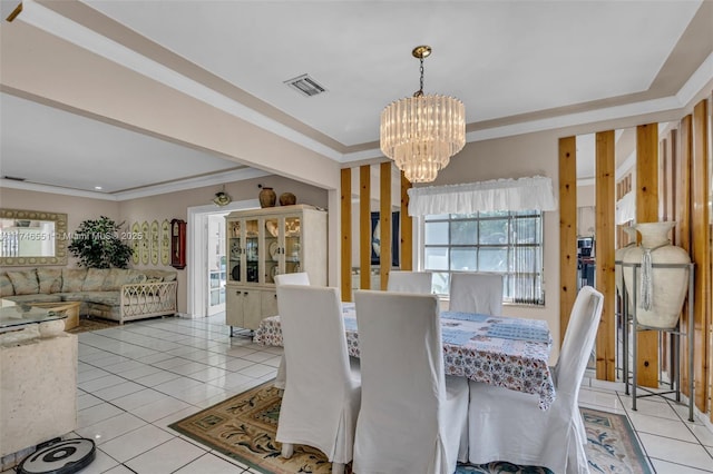 tiled dining room featuring ornamental molding and an inviting chandelier