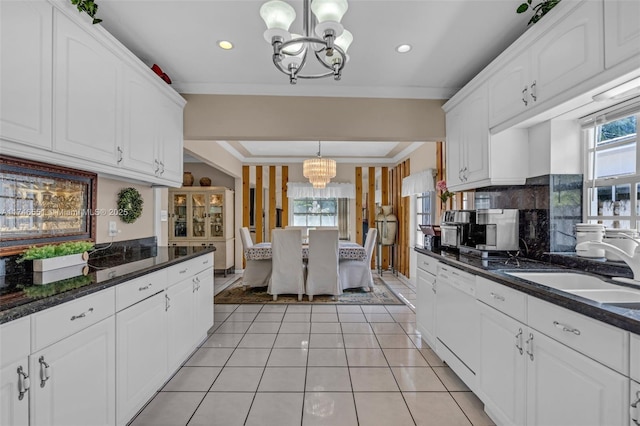 kitchen featuring an inviting chandelier, white dishwasher, pendant lighting, and white cabinetry