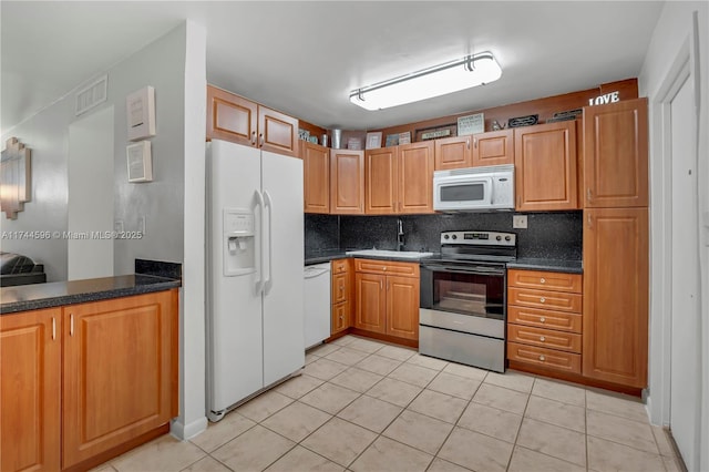 kitchen with white appliances, dark countertops, backsplash, and visible vents