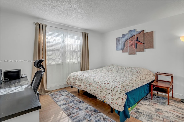 bedroom with hardwood / wood-style floors and a textured ceiling