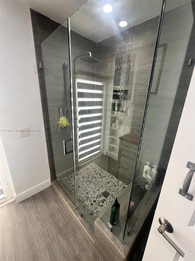 766 E 48th St, Hialeah, FL 33013 - full bathroom featuring baseboards, a shower stall, and wood finished floors