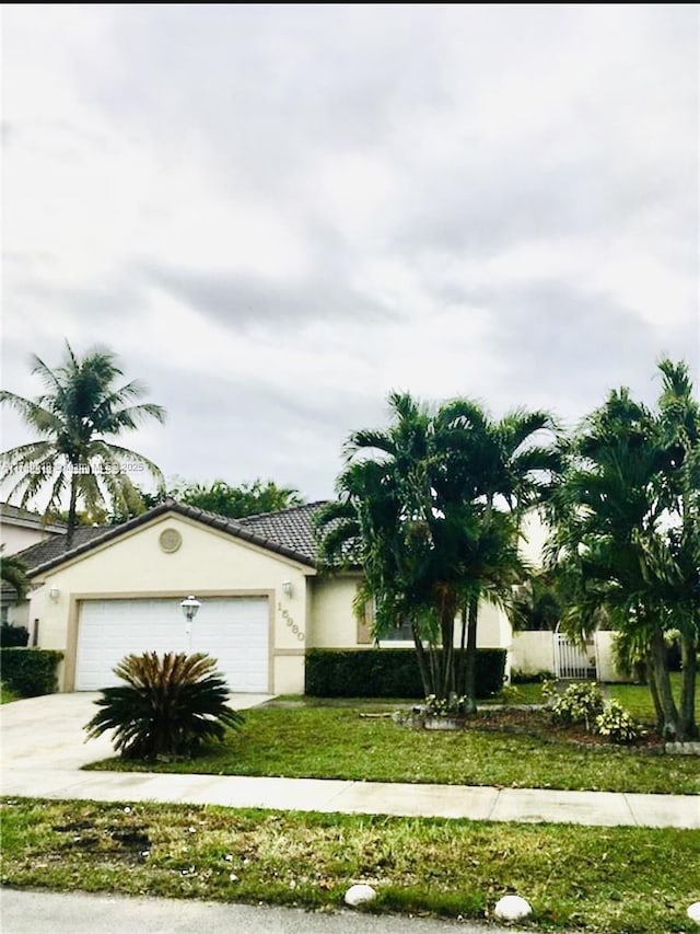 view of front facade featuring a garage, fence, driveway, and stucco siding