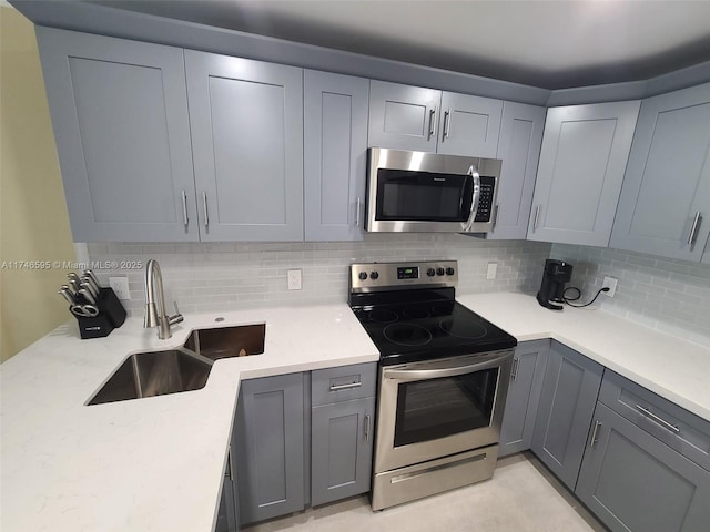 2851 NE 183rd St Unit 511E, Aventura, FL 33160 - kitchen with sink, gray cabinetry, stainless steel appliances, light stone countertops, and decorative backsplash