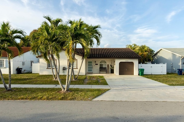 mediterranean / spanish house with a garage and a front yard