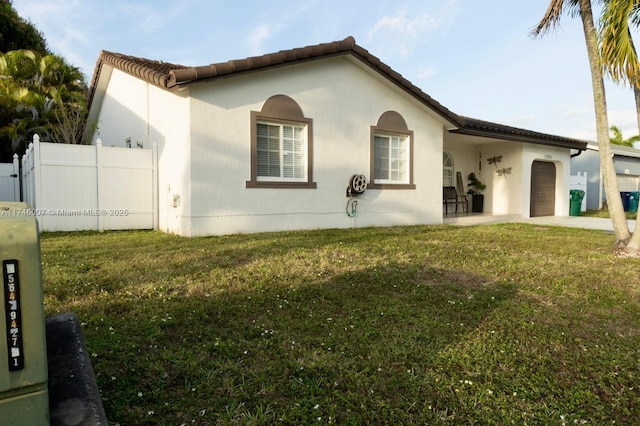 back of house with a garage and a lawn