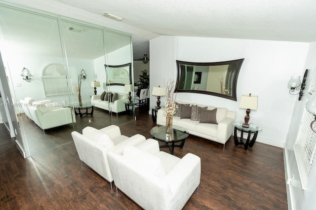 living room with dark hardwood / wood-style flooring and a textured ceiling