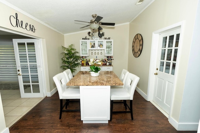 dining space featuring crown molding, dark wood-type flooring, and ceiling fan