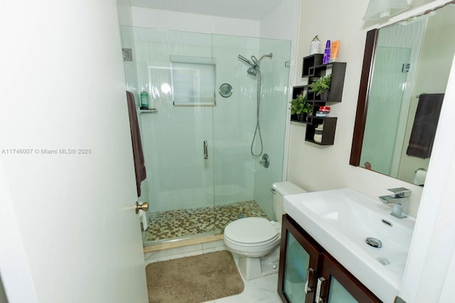 bathroom featuring vanity, a shower with shower door, and toilet