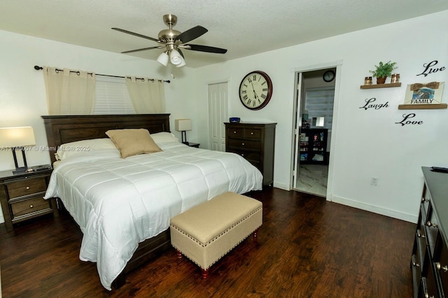 bedroom with ceiling fan, dark hardwood / wood-style floors, a textured ceiling, and a closet