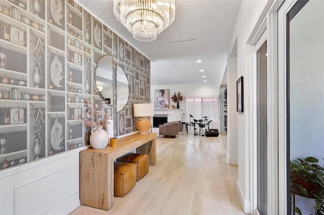 corridor featuring recessed lighting, an inviting chandelier, and wood finished floors