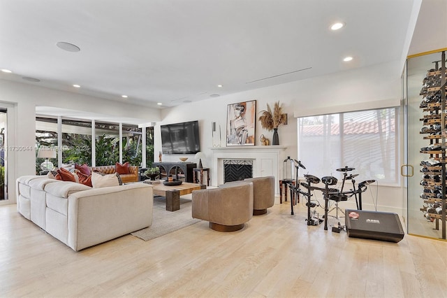 living area with wood finished floors, a high end fireplace, and recessed lighting