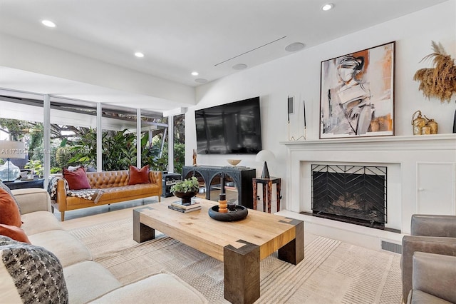 living room with a premium fireplace, plenty of natural light, visible vents, and recessed lighting