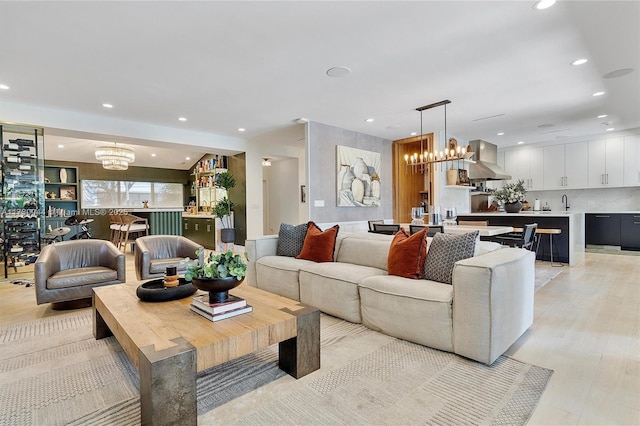 living area with a chandelier, light wood-type flooring, and recessed lighting