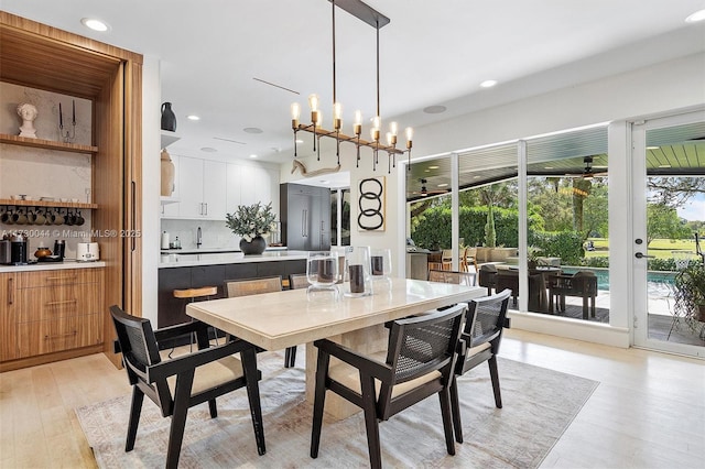 dining room featuring a notable chandelier, light wood-style flooring, and recessed lighting