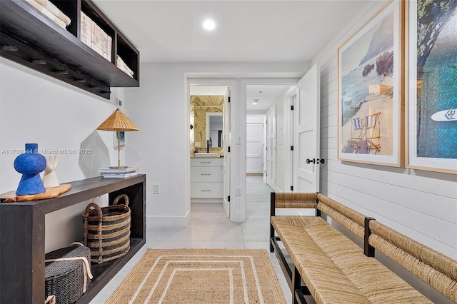 mudroom with light tile patterned floors, baseboards, a sink, and recessed lighting