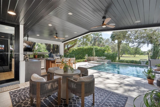 view of patio with an outdoor pool, ceiling fan, grilling area, and an outdoor kitchen