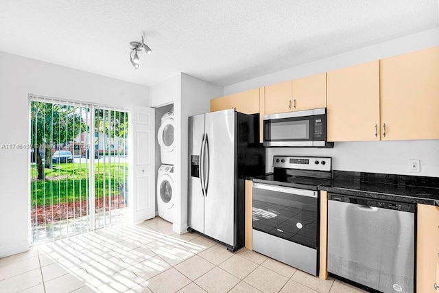 3505 Briar Bay Blvd Unit 104, West Palm Beach, FL 33411 - kitchen with appliances with stainless steel finishes, stacked washer / dryer, light tile patterned flooring, dark countertops, and a textured ceiling