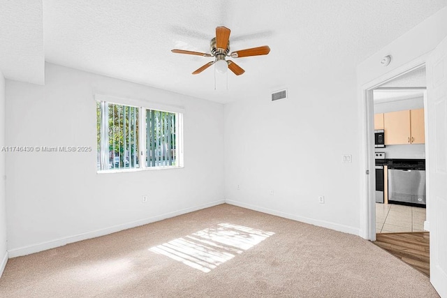 3505 Briar Bay Blvd Unit 104, West Palm Beach, FL 33411 - spare room featuring light colored carpet, ceiling fan, baseboards, a textured ceiling, and a smoke detector